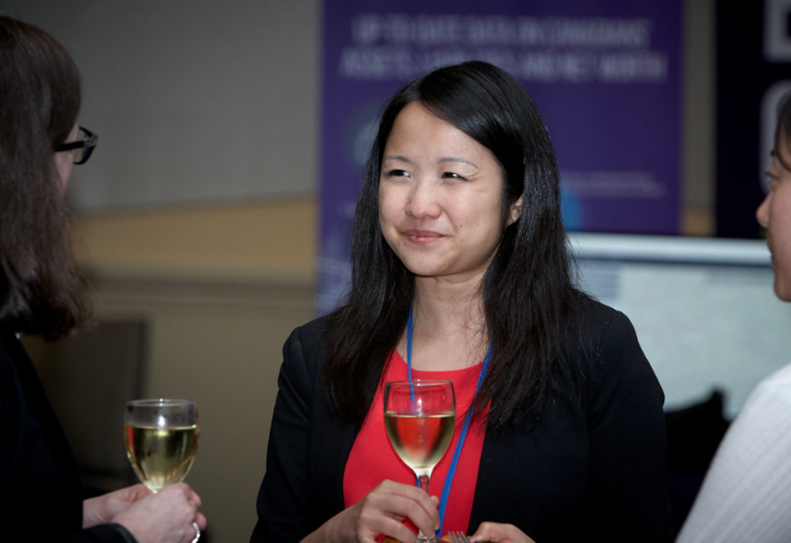 woman at a meet and great with a glass of wine